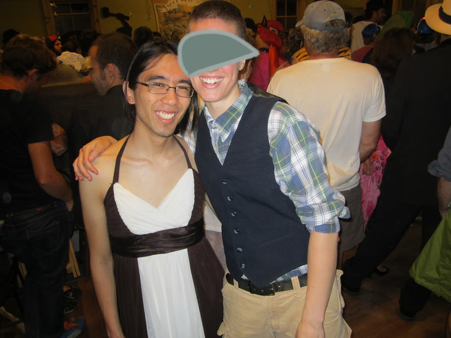 Marina wearing a brown and white prom-style dress, standing by Alex in a crowded room.